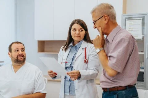 Experienced doctors analyzing x-ray film, checking lungs for health problems Stock Photos
