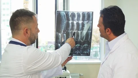 Experienced doctors are studying the X-Ray of their patient Stock Footage 80996107