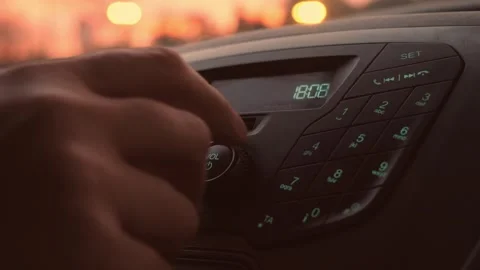 Experienced driver adjusting volume and equalizer at sunset Stock Footage 328643820