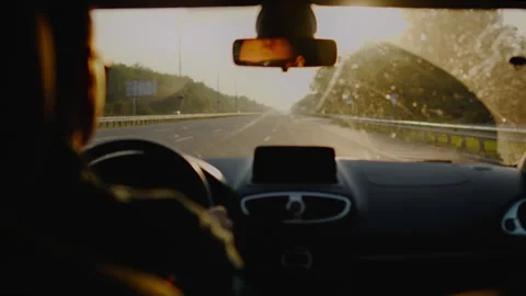 An experienced driver drives a car along a devastated highway on a bright su Stock Footage 252387076