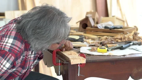 Experienced elderly carpenter focuses on his work in carpentry shop, small .. Stock Footage 243190883