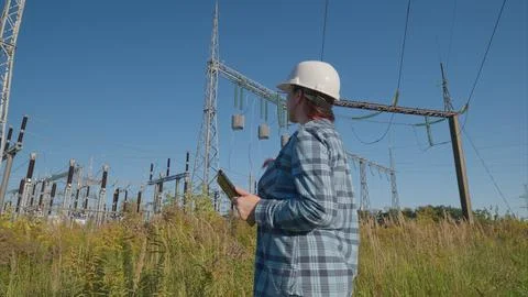 Experienced Engineer Analyzing Complex Data in a Power Substation Working Enviro Stock Photos