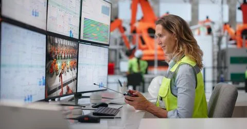 Experienced Engineer Controls Robotic Arms Remotely For Advanced Vehicle Asse Stock Photos