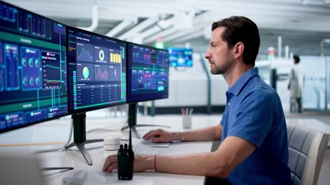 Experienced Engineer Monitors Modern SCADA System Stock Footage 334930297