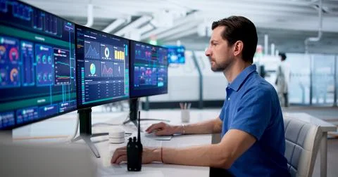 Experienced Engineer Monitors Modern SCADA System To Control Factory Process  Stock Photos