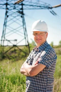 Experienced engineer with white hard hat under the power lines. Foto stock