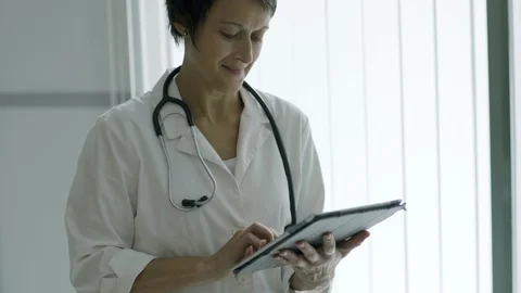 Experienced female doctor using tablet computer Stock Footage 103472942
