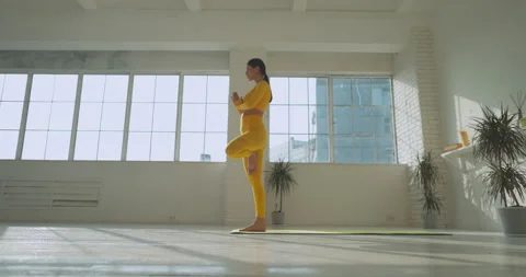 Experienced female yoga practitioner doing asanas in white studio. Athletic Vidéo 154332925