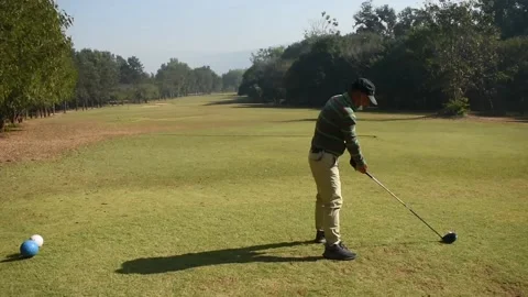 Experienced golfer in the face mask kicks the ball very far (sound included) Stock Footage 146483430