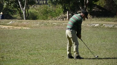 Experienced golfer in the face mask kicks the ball very far (sound included) Stock Footage 146484005