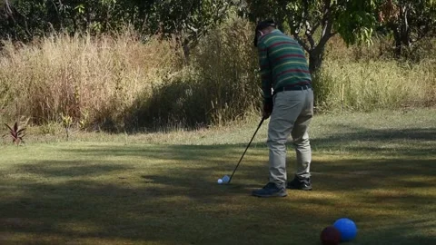 Experienced golfer in the face mask kicks the ball very far (sound included) Stock Footage 146484247