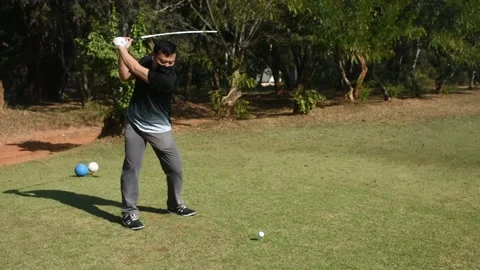 Experienced golfer in the face mask kicks the ball very far (sound included) Stock Footage 146493389
