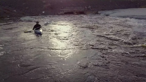 Experienced guy sails upstream along wide swirling river Stock Footage 122492978