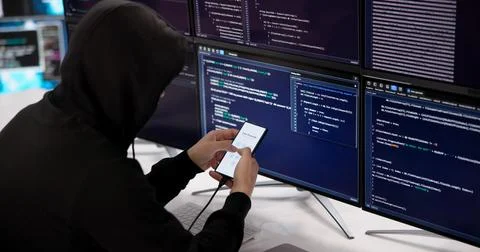 Experienced Hacker Methodically Attempts To Unlock Smartphone PIN In Dark Set Stock Photos