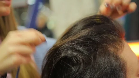 Experienced hair stylist creating beautiful hairstyle for female customer Stock Footage