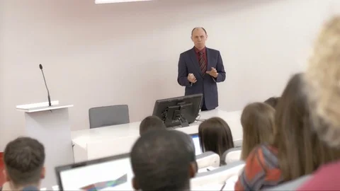 Experienced lecturer gesturing while giving a speech to students Stock Footage 69929697