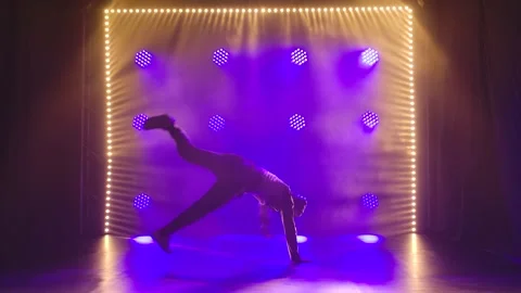 An experienced male dancer performs complex breakdancing elements and rotates on Stock Footage 138917699