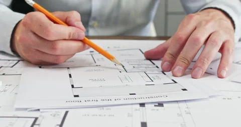 Experienced man architect moves compass across sketch of room Stockbeeldmateriaal 314730523