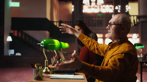 Experienced man rehearsing a theatre script in a quiet library Stock Footage 313305765