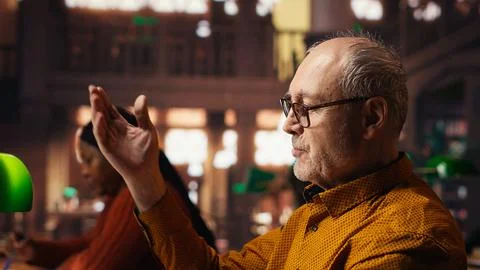Experienced man rehearsing a theatre script in a quiet library Stock Photos