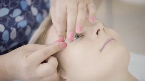 Experienced masseur makes forehead eyebrows massage of lying woman in spa salon Video stock 78581351