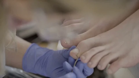 Experienced master processes foot nail of client in beauty studio. Stock Footage 83294321
