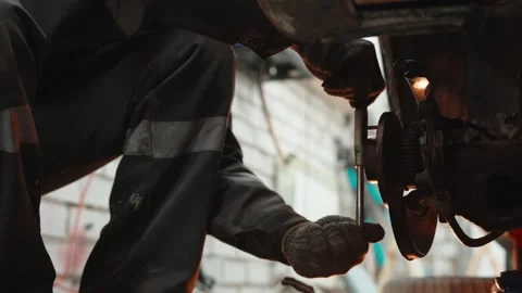 Experienced mechanic checking brake system, using specialized wrench in garage Stock Footage 304674027