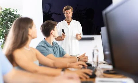Experienced mentor explaining assigned tasks to young developers at IT startup Stock Photos