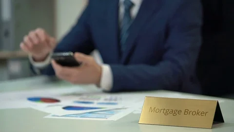 Experienced mortgage broker using mobile app, studying situation on market Stock-Footage 71605456