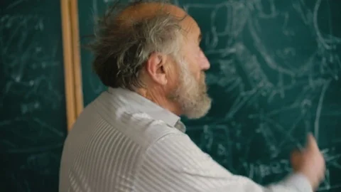 Experienced old teacher explaining at the blackboard the schemes 4K 스톡 동영상 76949017