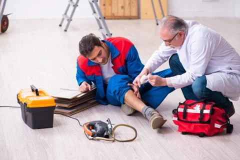 Experienced paramedic helping workman bitten by snake Foto stock