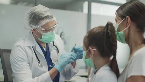 An experienced pediatrician makes a routine vaccination for a little girl, he Stock Footage 150334389
