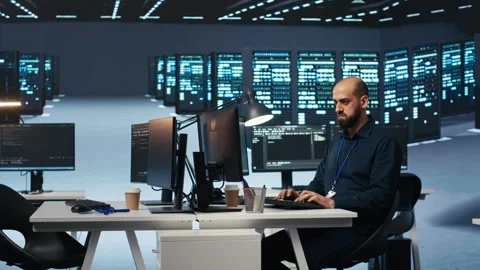 Experienced person typing code on computer monitors in data center Stock Footage 275478795