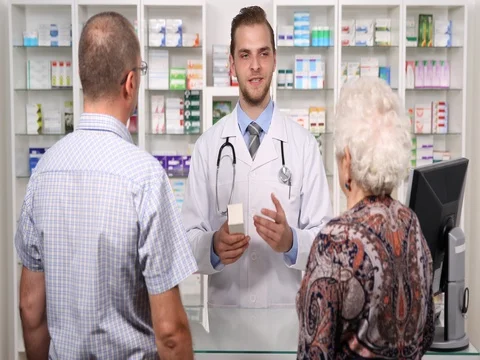 Experienced Pharmacist Man Talking with Client Pharmacy About Drugs Instructions Stock Footage 70677332