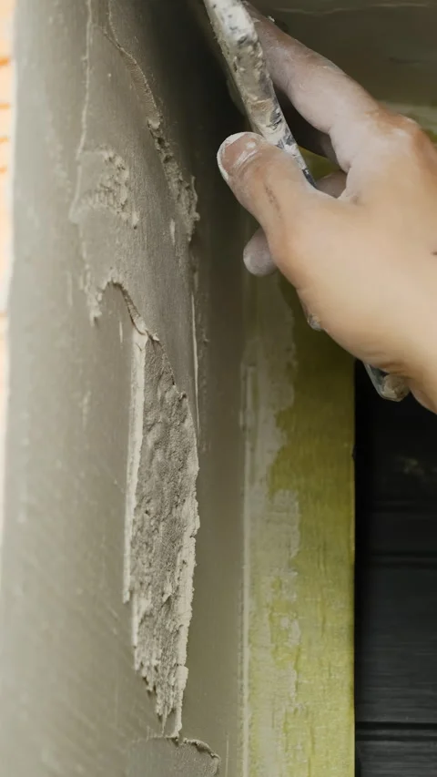 Experienced plasterer applies coat of plaster using spatula Stock Footage 317081864
