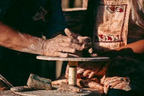 An experienced potter teaches an apprentice to work with clay and a potter's  Foto stock