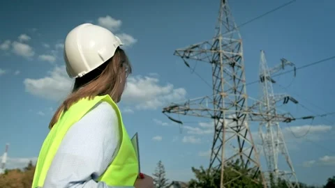 Experienced power engineer inspecting high-voltage electric lines on site Stock Footage 270060425