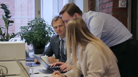 Experienced programmer helps employees using laptop in large company. Stock-Footage 83406989