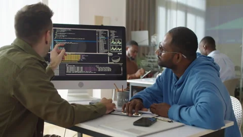 Experienced Programmer Showing Coding Script on PC to Male Newcomer at Office Stock Footage 277413787