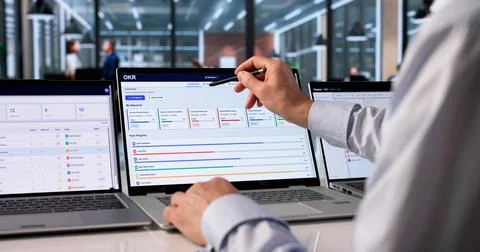 Experienced Project Manager Analyzes OKR Dashboard To Track Team Progress. Stock Photos