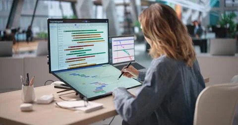 Experienced Project Manager Uses Touchscreen Computer To Plan Team Schedule E 库存照片