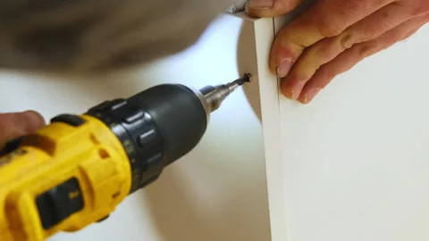 Experienced repairman creates hole in panel of cabinet Stock Footage 304402972