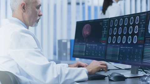 Experienced Senior Scientist Working with CT/ MRI Brain Scan Images on a PC Stock Footage 91761907
