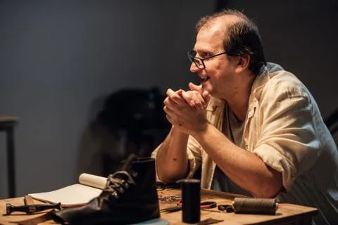 An experienced shoemaker conducts a master class on making shoes from leather in Stock Photos