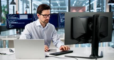Experienced Software Programmer Coding Secure Web Applications At His Desk. Foto stock