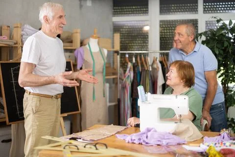 Experienced tailor explaining pattern modeling on chalkboard during course for Stock Photos