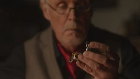 Experienced Watchmaker checking an item using the magnifying glass Stock Footage 258300993