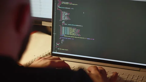 An experienced web developer writes the code for a website. A male programmer Stock Footage 236564267