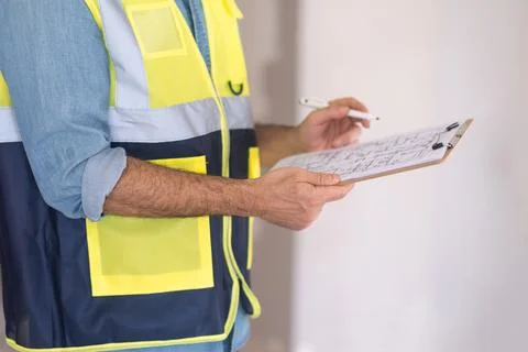 Experienced worker checking and correcting construction documents on clipboard Stock Photos