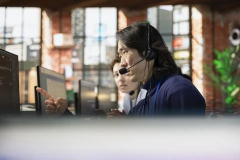 Experienced worker doing customer support job using PC to troubleshoot problems Foto stock
